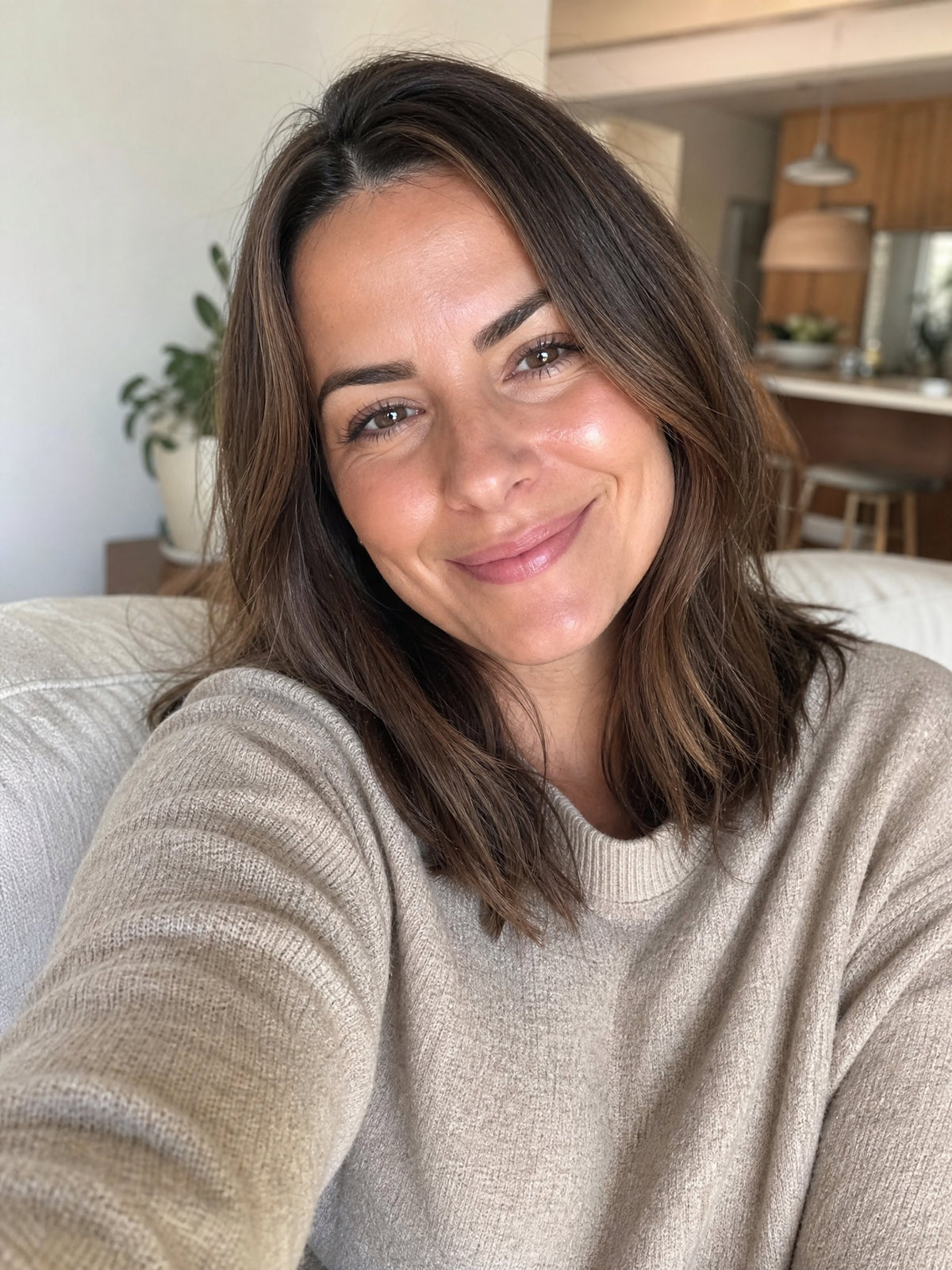 Un selfie di una donna che sorride alla fotocamera.